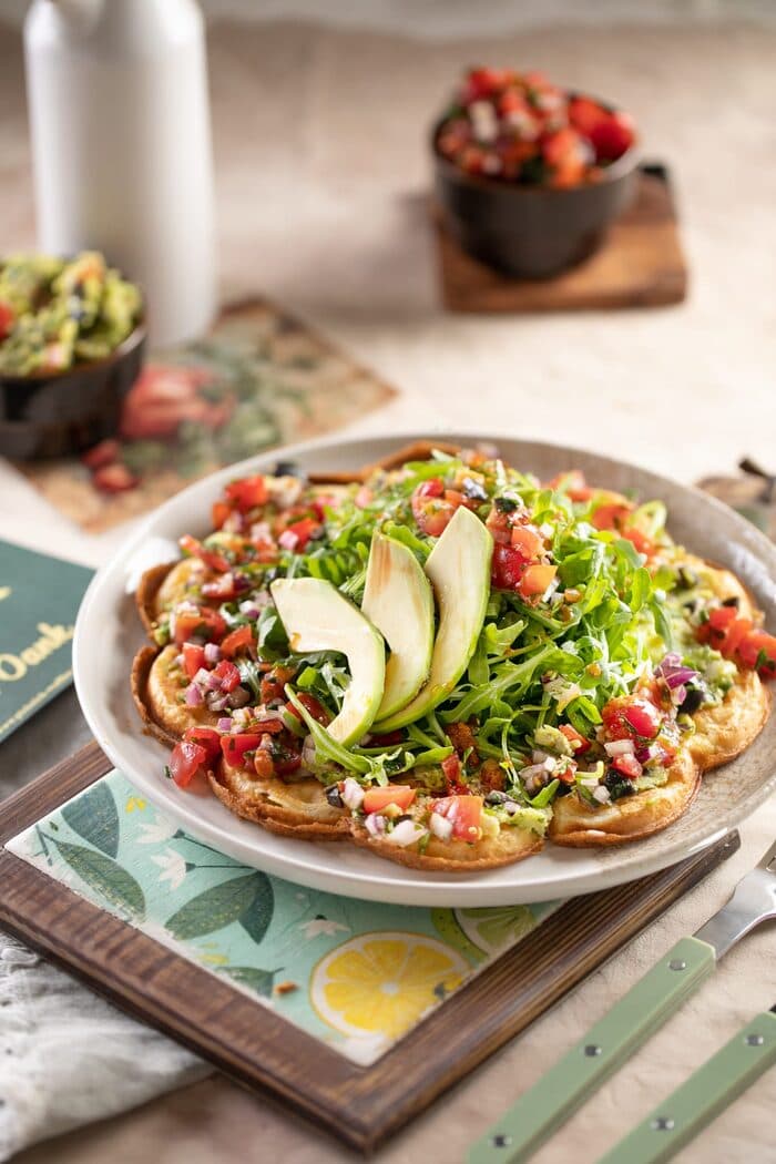 Herzhafte Waffel mit Avocado, Rucola und Tomaten auf einem Teller bei Picknick Waffles and More